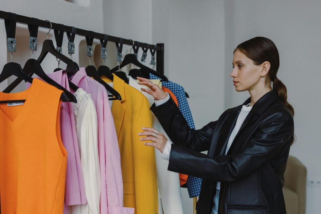Side view of a woman browsing colorful fashion collection in a modern store.